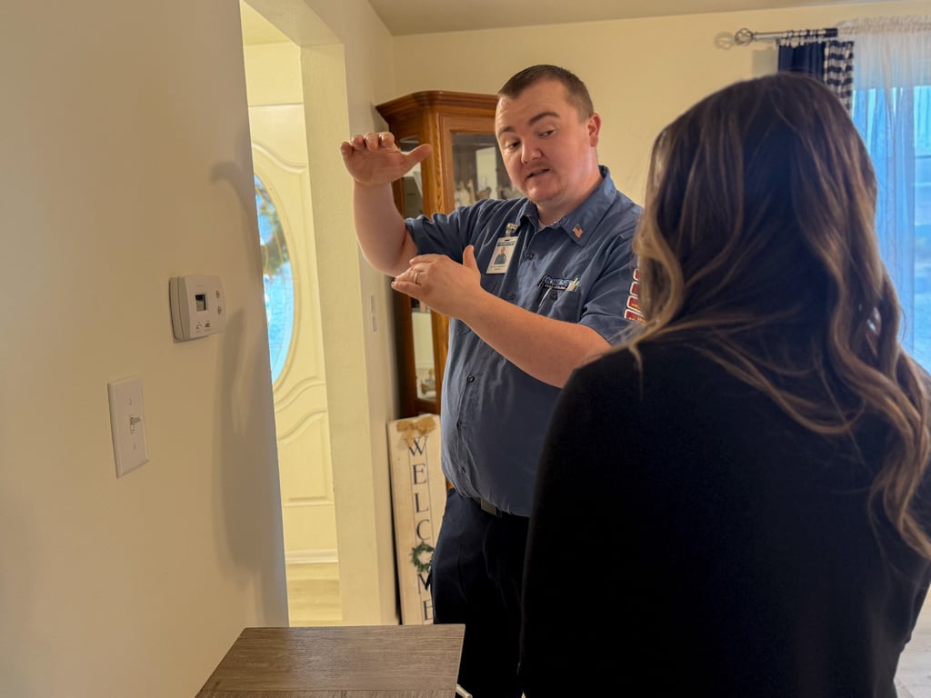 Honest Fix owner Alex Largent explaining thermostat and HVAC recommendations to a homeowner inside a home in Steubenville, Ohio.