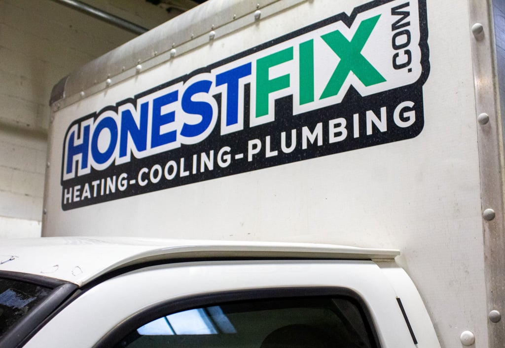 Close-up of Honest Fix Heating Cooling Plumbing branding on a service truck.