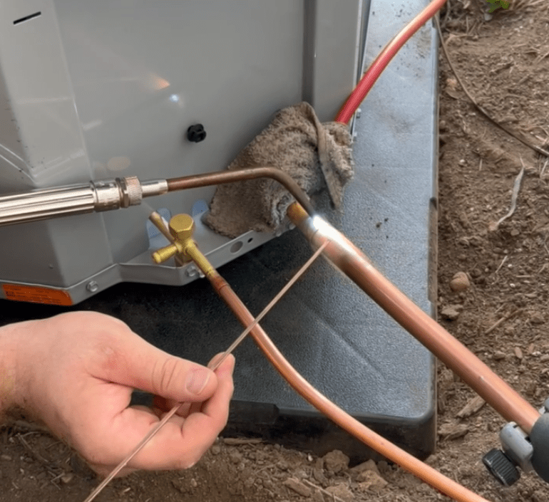 Honest Fix technician brazing a copper line set to a condenser unit during an air conditioner installation in Steubenville, OH.