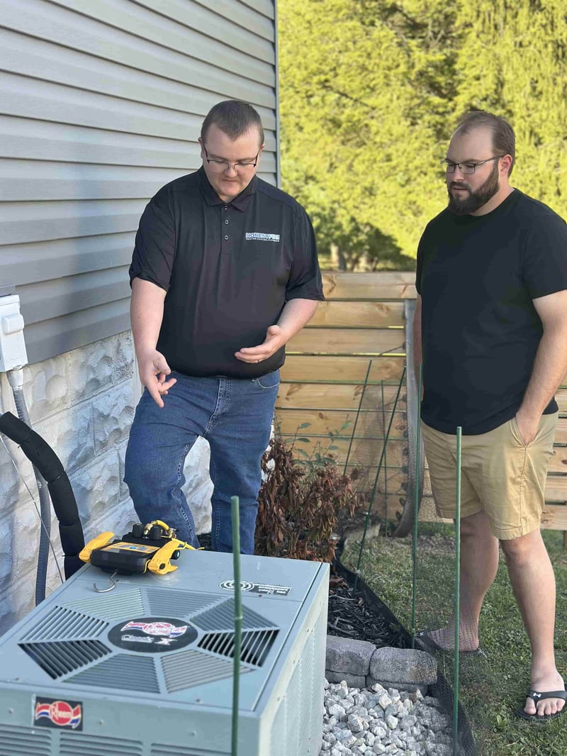 Owner Alex Largent of Honest Fix Heating, Cooling & Plumbing explaining air conditioner repair options to a homeowner in Steubenville, OH.