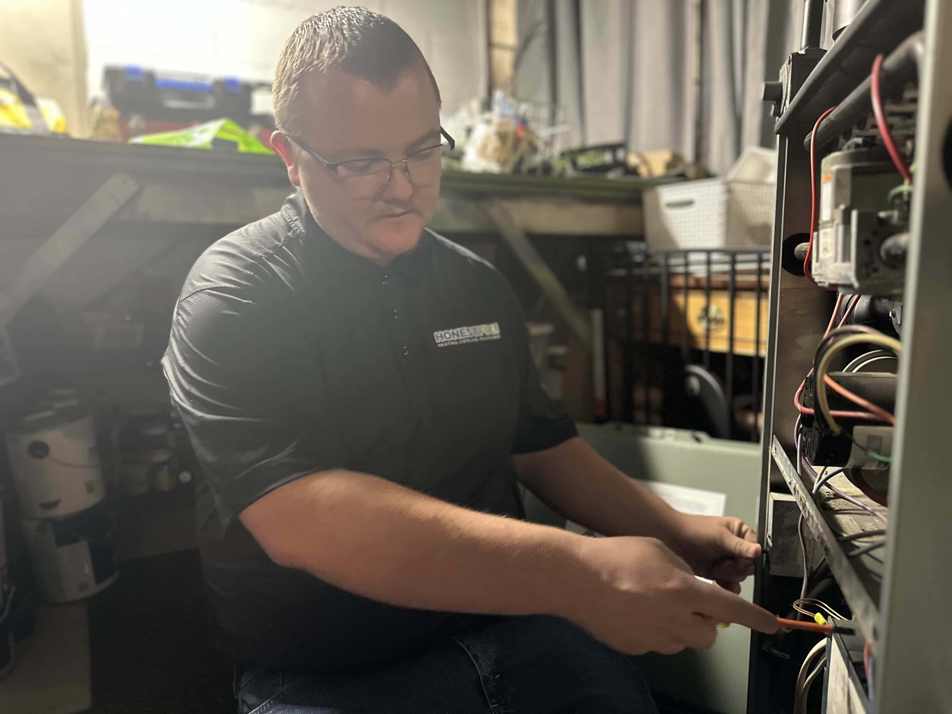 Owner Alex Largent of Honest Fix inspecting a homeowner’s furnace during a heating repair in Steubenville, Ohio.