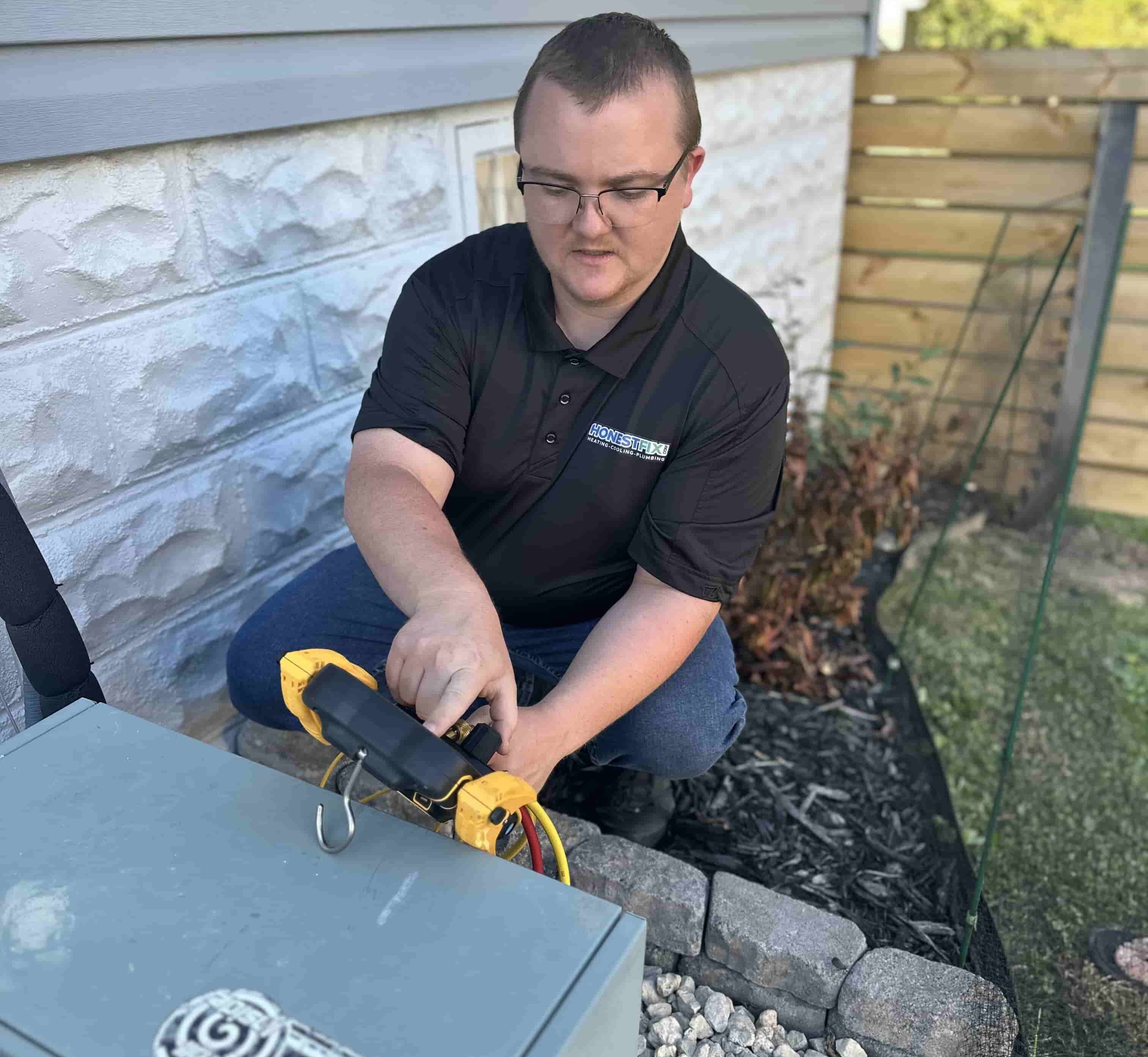 Owner Alex Largent of Honest Fix Heating, Cooling & Plumbing performing HVAC system diagnostics outside a home in Steubenville, OH.
