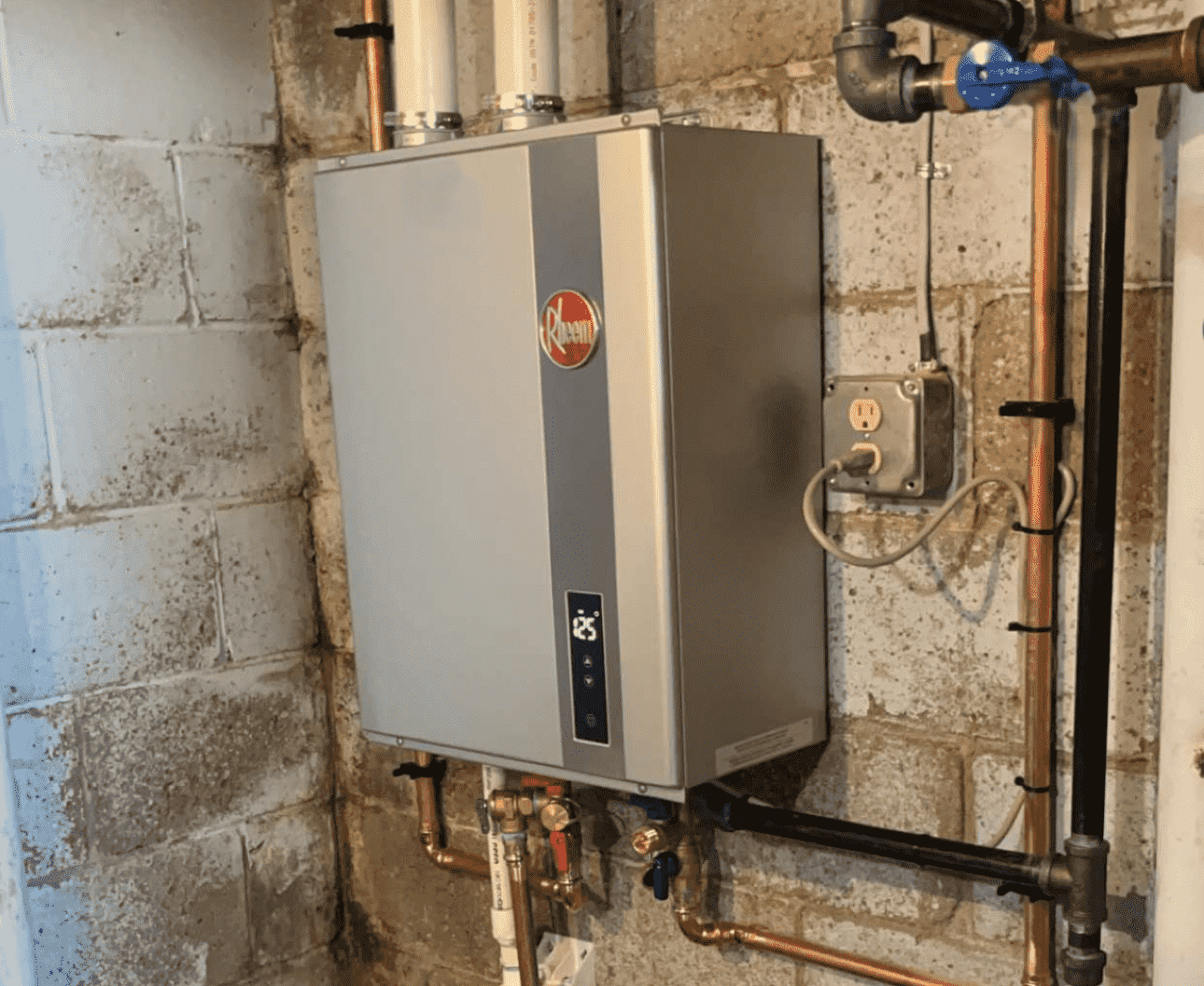 Honest Fix technician installation of a Rheem tankless water heater with copper piping and shutoff valves in a Steubenville OH basement