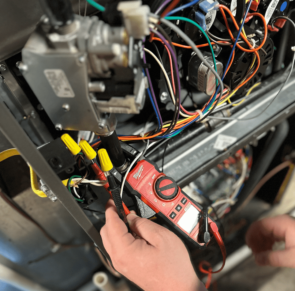 Honest Fix Heating, Cooling & Plumbing technician performing electrical diagnostics on a furnace control board in Steubenville, OH.